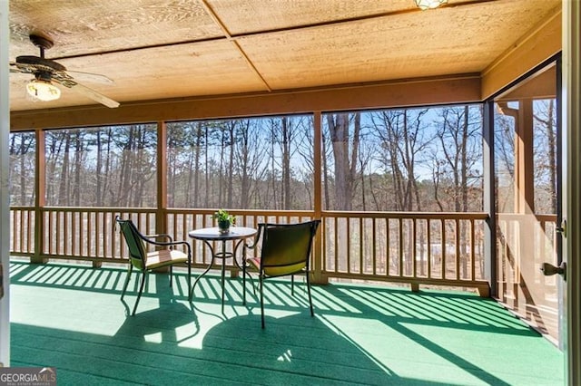 sunroom / solarium featuring a ceiling fan