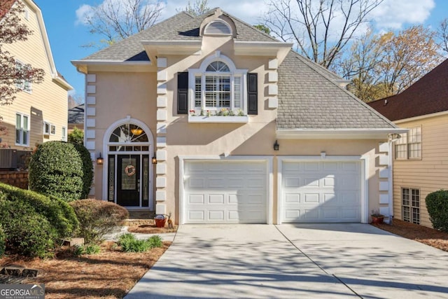 traditional-style home with stucco siding, concrete driveway, and a shingled roof