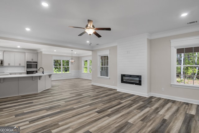 243 Barrington Oaks Dr, Brunswick, GA 31523 - unfurnished living room with wood finished floors, ceiling fan, ornamental molding, visible vents, and recessed lighting