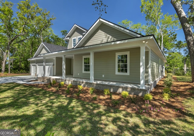 243 Barrington Oaks Dr, Brunswick, GA 31523 - farmhouse with concrete driveway, a front lawn, a garage, and covered porch
