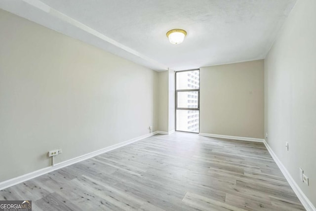 620 Peachtree St NE Unit 1413, Atlanta, GA 30308 - unfurnished room with floor to ceiling windows, baseboards, and wood finished floors