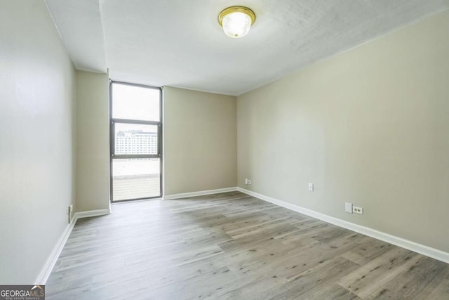 620 Peachtree St NE Unit 1413, Atlanta, GA 30308 - spare room with baseboards, expansive windows, and wood finished floors