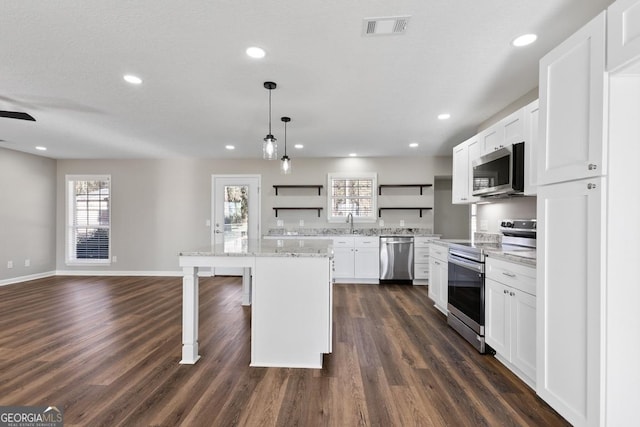 kitchen with open shelves, a kitchen bar, appliances with stainless steel finishes, dark wood-style floors, and visible vents