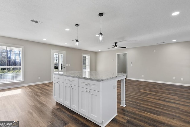 kitchen with open floor plan, dark wood finished floors, ceiling fan, and visible vents