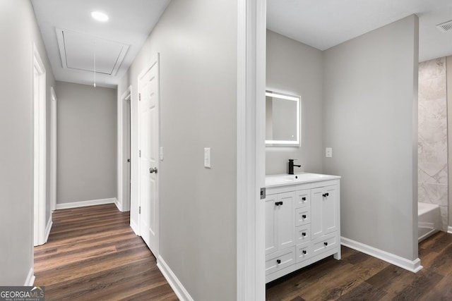 corridor with a sink, baseboards, attic access, and dark wood finished floors