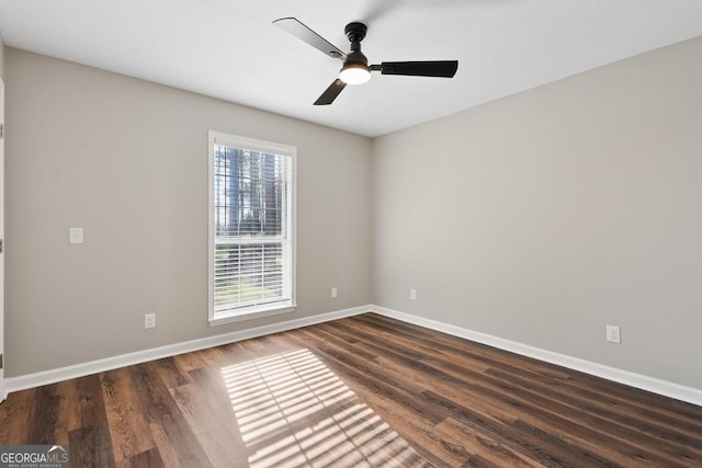 unfurnished room featuring a ceiling fan, dark wood-style flooring, and baseboards