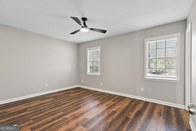 unfurnished room featuring baseboards, dark wood-type flooring, and a ceiling fan
