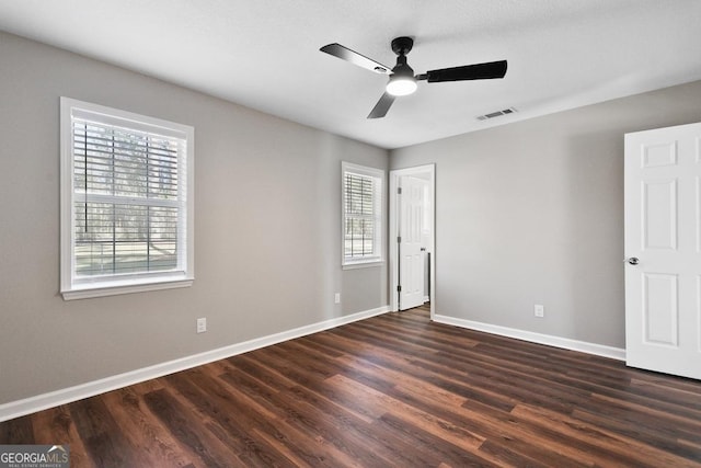 unfurnished bedroom with dark wood finished floors, baseboards, ceiling fan, and visible vents