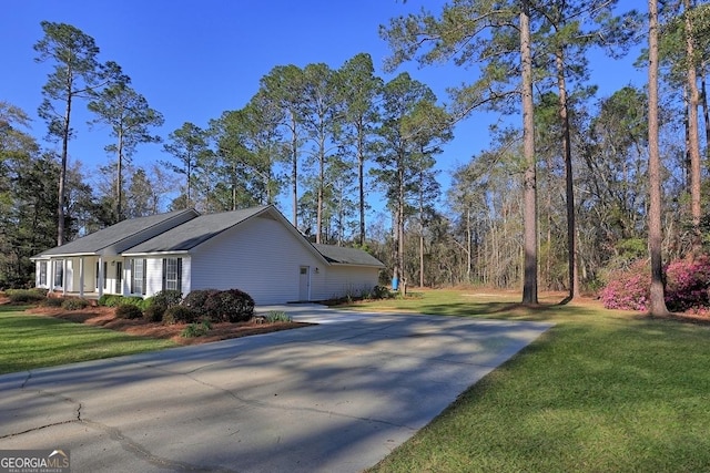 view of property exterior with concrete driveway and a yard
