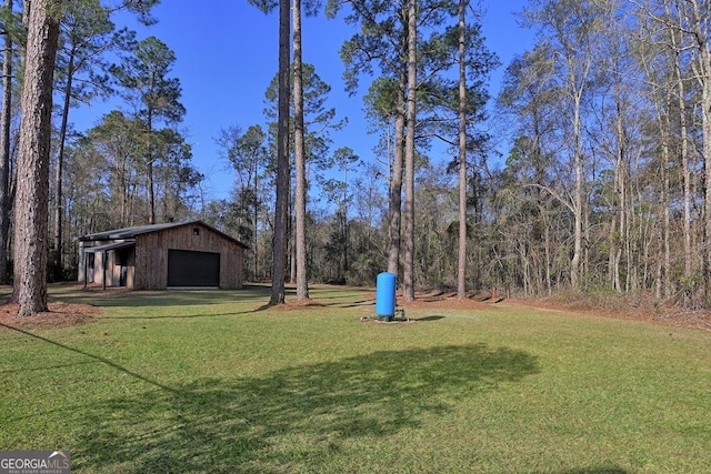 view of yard featuring a detached garage and an outdoor structure
