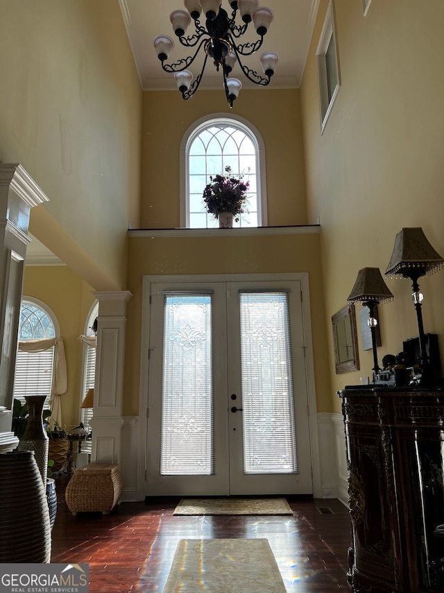 foyer with a chandelier, wood finished floors, plenty of natural light, and french doors