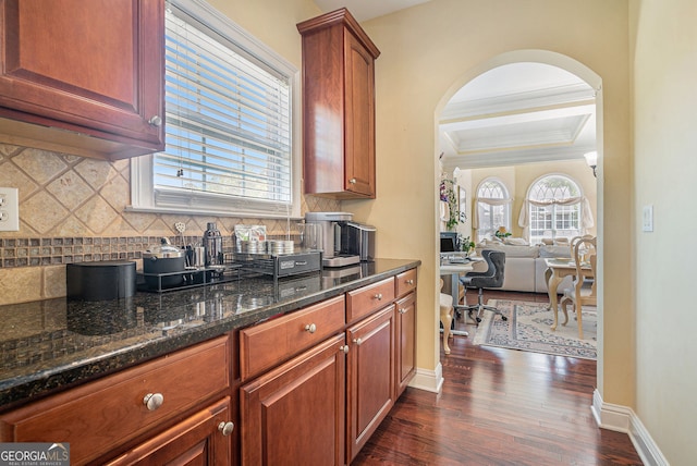 kitchen with baseboards, dark wood finished floors, tasteful backsplash, and crown molding