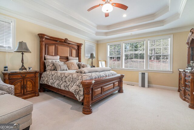 bedroom featuring light carpet, a tray ceiling, and ornamental molding
