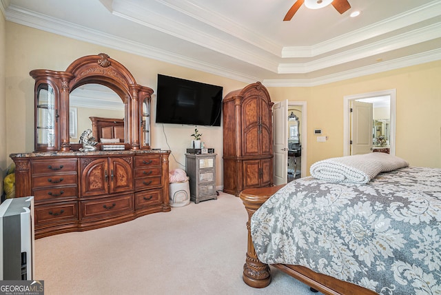 bedroom with a tray ceiling, carpet, crown molding, and a ceiling fan