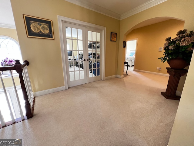 doorway to outside with arched walkways, carpet, crown molding, and french doors