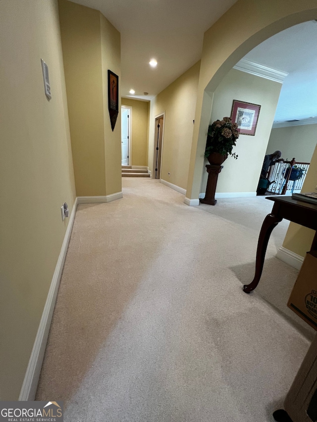 corridor featuring arched walkways, carpet, baseboards, and recessed lighting