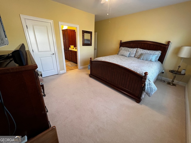 bedroom featuring connected bathroom, light carpet, and baseboards