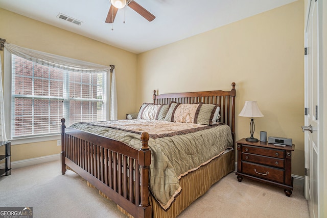 bedroom with baseboards, visible vents, a ceiling fan, and light colored carpet