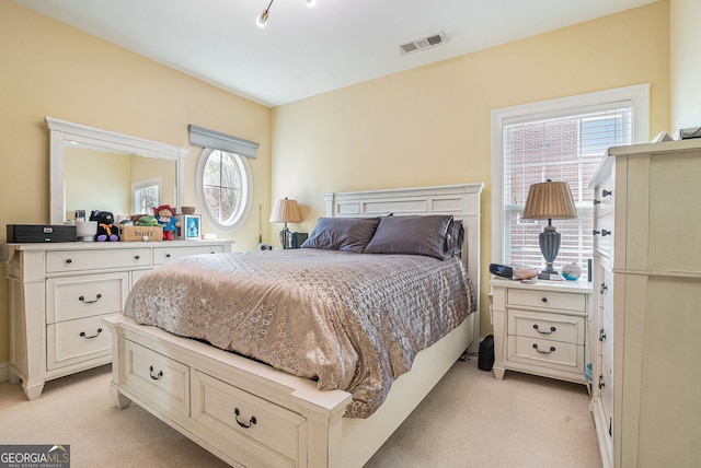 bedroom featuring light colored carpet and visible vents