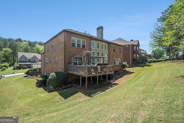 back of property featuring brick siding, a yard, and a deck