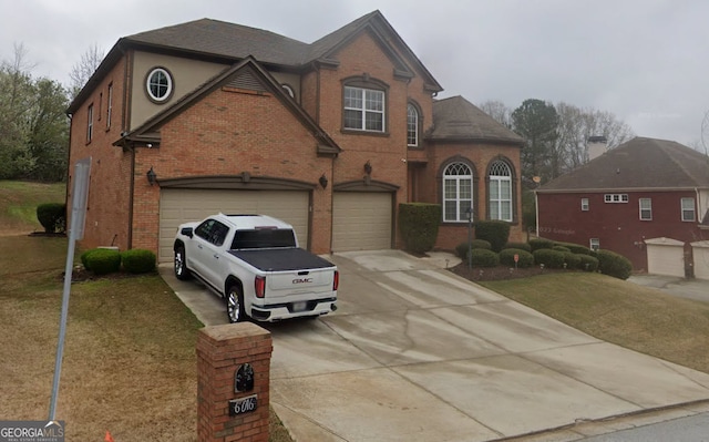 view of front of house featuring driveway, brick siding, a front yard, and a garage