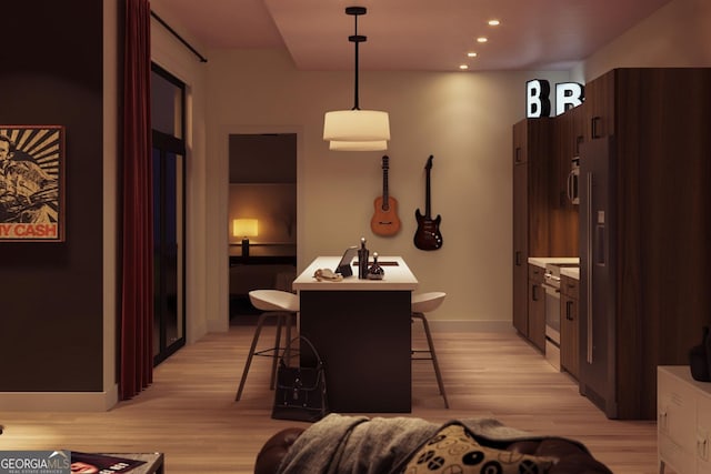 hall featuring light wood-style flooring, baseboards, and recessed lighting