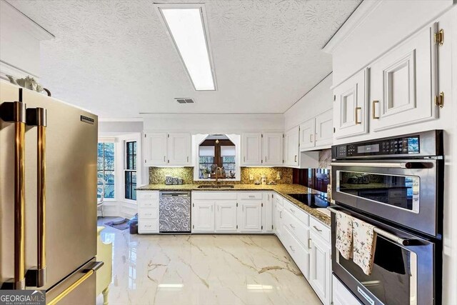 kitchen with white cabinets, marble finish floor, appliances with stainless steel finishes, and visible vents