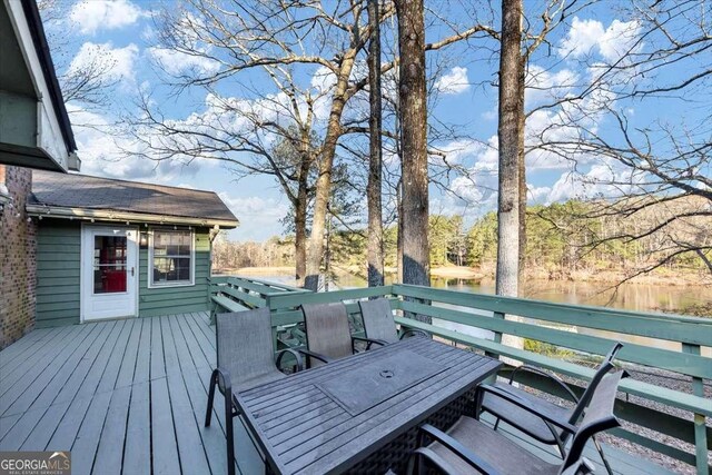 wooden terrace featuring a water view and outdoor dining area