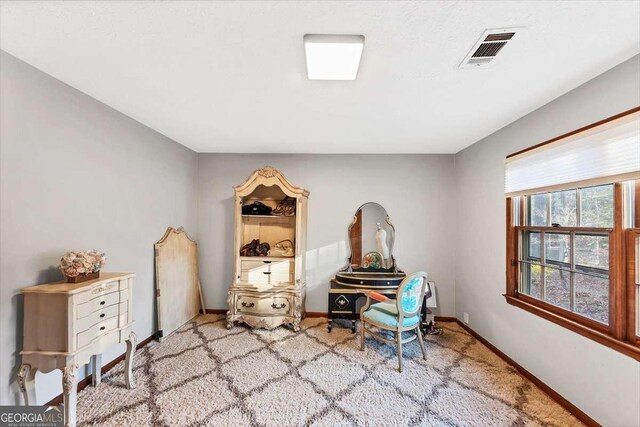 interior space featuring baseboards, visible vents, and carpet flooring