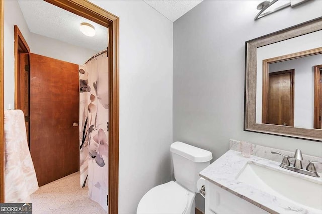 bathroom with a textured ceiling, toilet, and vanity