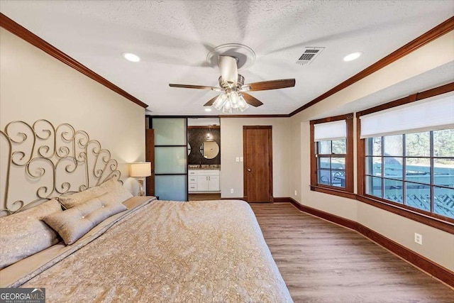 unfurnished bedroom featuring baseboards, a textured ceiling, wood finished floors, and crown molding