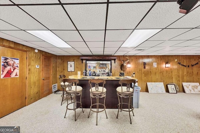 bar featuring bar area, wooden walls, and carpet