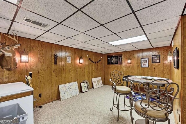 interior space featuring carpet, wooden walls, and visible vents