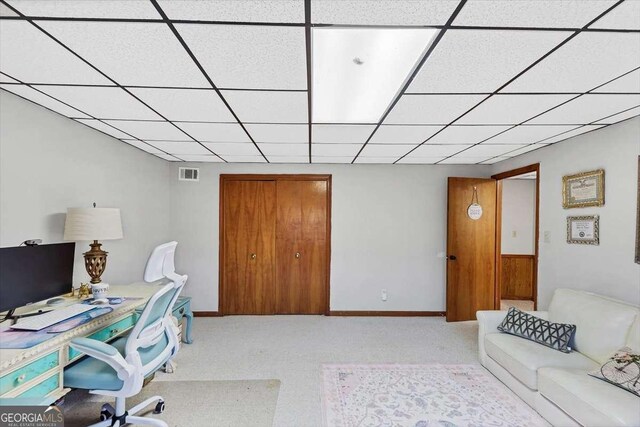 office area featuring light carpet, baseboards, visible vents, and a drop ceiling