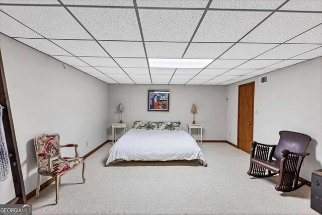 carpeted bedroom with baseboards, visible vents, and a drop ceiling