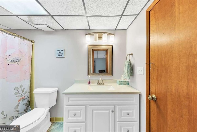 full bath with a drop ceiling, toilet, vanity, and a shower with curtain