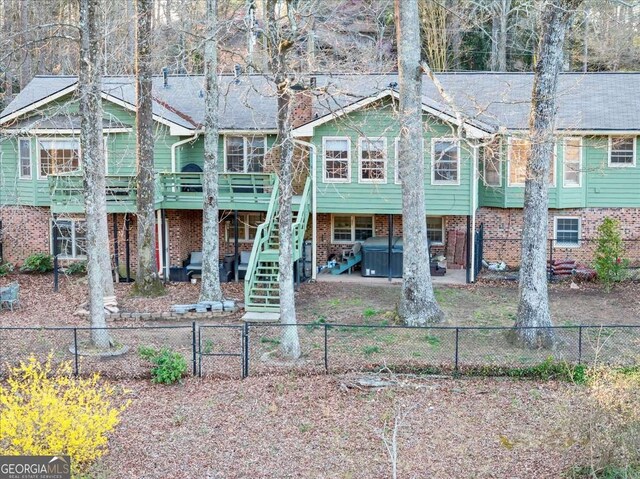 view of front facade featuring a fenced backyard, a deck, a patio, and stairway