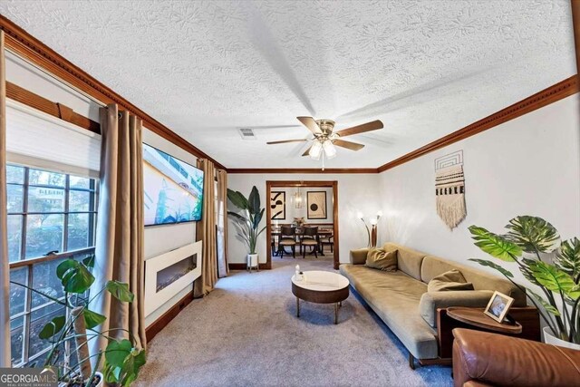 carpeted living area featuring a textured ceiling, a ceiling fan, visible vents, and crown molding