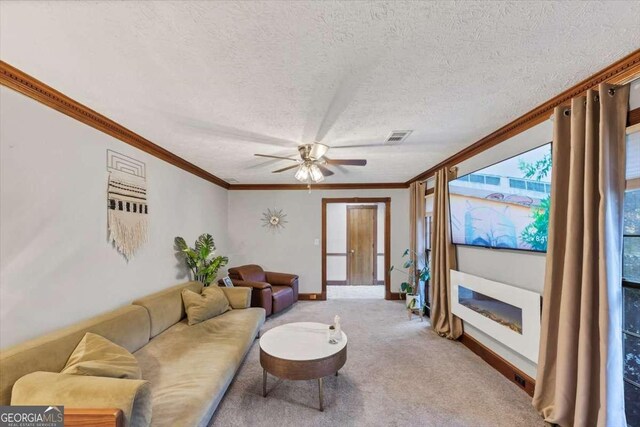 living room featuring a textured ceiling, visible vents, crown molding, a ceiling fan, and carpet floors