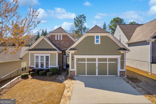 6754 Black Fox Dr, Hoschton, GA 30548 - craftsman-style house featuring stone siding, metal roof, an attached garage, a standing seam roof, and driveway