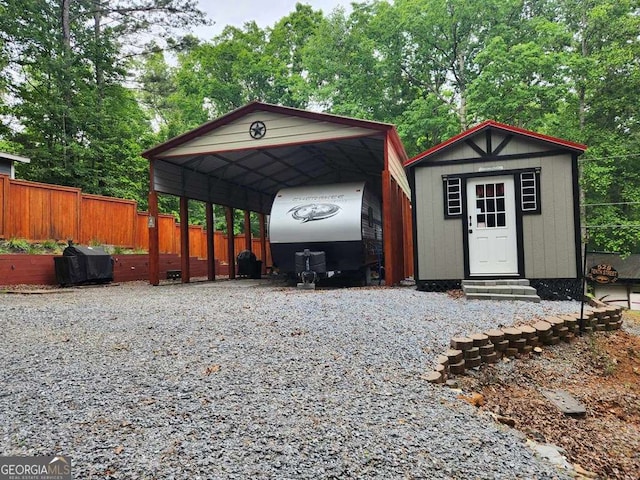 exterior space with a detached carport, entry steps, fence, and driveway