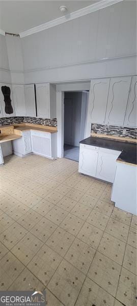 807 Elizabeth St, Waycross, GA 31503 - kitchen with white cabinetry, crown molding, and light floors
