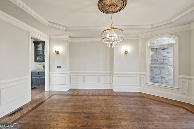 3491 Falls Branch Ct, Buford, GA 30519 - unfurnished dining area featuring a chandelier, dark wood finished floors, a tray ceiling, ornamental molding, and a wainscoted wall