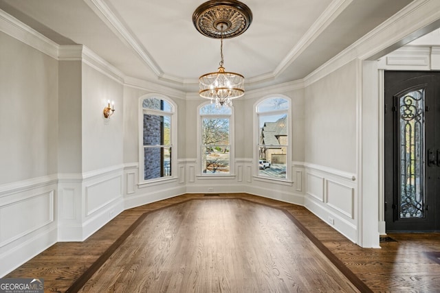 3491 Falls Branch Ct, Buford, GA 30519 - unfurnished dining area with a chandelier, wood finished floors, a raised ceiling, wainscoting, and a decorative wall