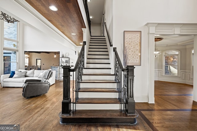 3491 Falls Branch Ct, Buford, GA 30519 - staircase featuring crown molding, wood finished floors, recessed lighting, a wainscoted wall, and a chandelier