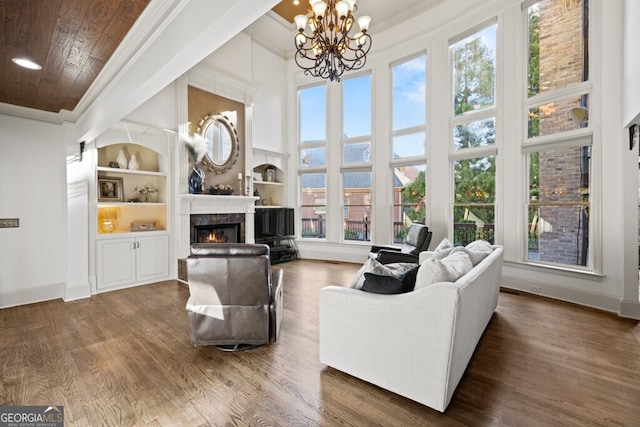 3491 Falls Branch Ct, Buford, GA 30519 - living area with baseboards, ornamental molding, a lit fireplace, built in shelves, and wood finished floors