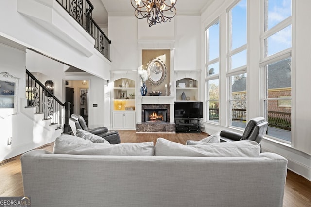 3491 Falls Branch Ct, Buford, GA 30519 - living room featuring a high ceiling, stairs, a chandelier, a premium fireplace, and built in features