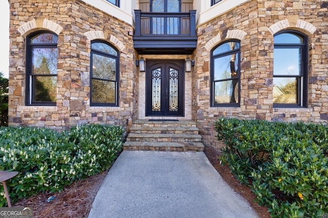 3491 Falls Branch Ct, Buford, GA 30519 - view of exterior entry featuring a balcony, stone siding, and french doors