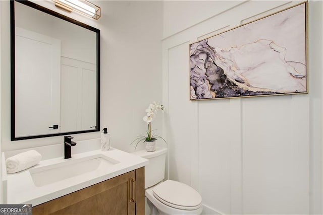 half bathroom featuring toilet and vanity
