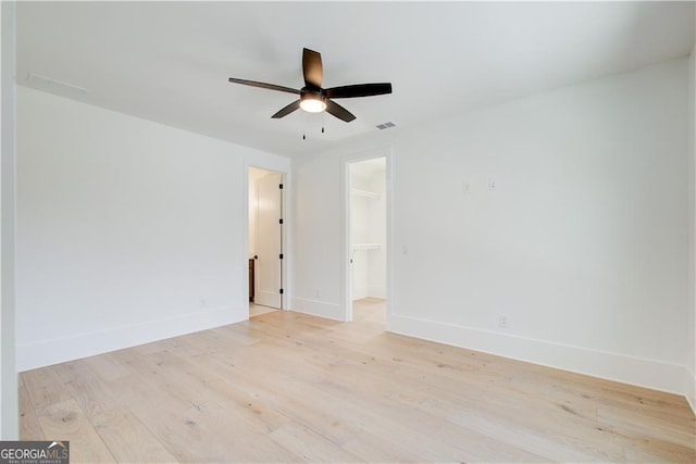 unfurnished room featuring baseboards, ceiling fan, and light wood-type flooring